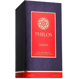 Sticla parfum Maison Alhambra Philos Shine 100 ml, flacon rosu intens cu eticheta aurie si capac in forma de coroana.